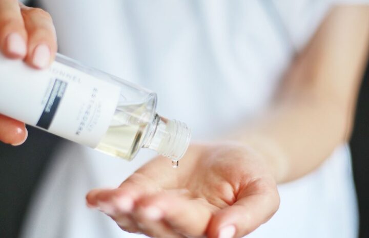 close up of woman pouring liquid on hand