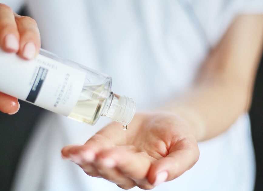 close up of woman pouring liquid on hand